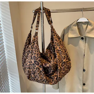 Detailed view of leopard print tote bag with adjustable strap on metal hanger
