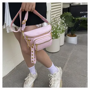 Dettaglio della borsa a tracolla rosa in pelle PU con zip dorate e catena decorativa