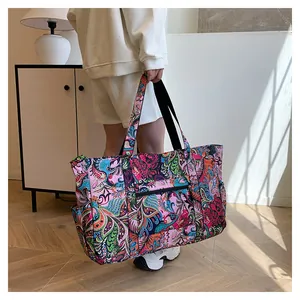 Detalle del bolso de viaje de nailon impermeable con estampado paisley y bolsillos