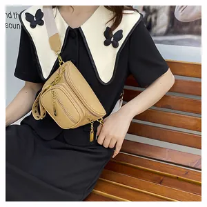 Dettaglio borsa a tracolla beige in pelle martellata con doppia cerniera e tracolla larga