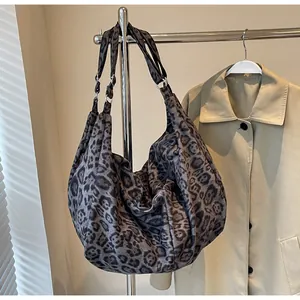 Macro view of leopard print tote bag texture with metal ring and shoulder strap detail
