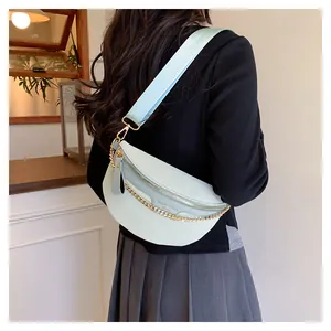 Détail d'un sac bandoulière vert clair motif crocodile avec chaîne dorée et sangle