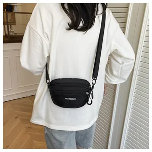 Adjustable black nylon crossbody bag with durable zippers shown on person from behind