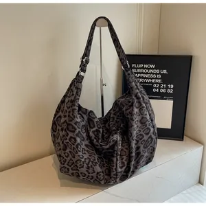 Detailed macro view of leopard print shoulder bag with silver adjustable metal buckle