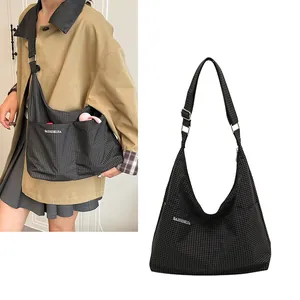 Détail du sac hobo en toile à carreaux avec bandoulière réglable et poches externes