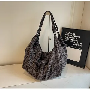 Detailed view of leopard print hobo bag with adjustable metal buckle on a shoulder strap