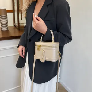Detail der minimalistischen beigen Vanity Bag mit goldener Hardware und Kunstleder