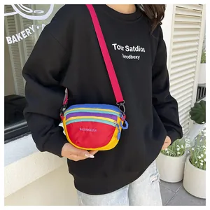 Detailed close-up of a colorful nylon crossbody bag with multi-color patchwork and red strap