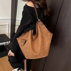 Vue détaillée d'un sac cabas en daim marron avec sa petite pochette assortie