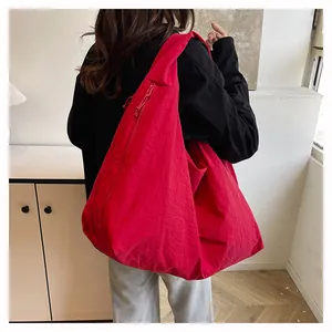 Dettaglio della borsa tote rossa in nylon con zip verticale e design ampio da ufficio