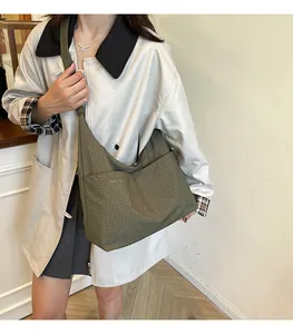 Vue détaillée du sac hobo en toile à carreaux vert olive avec sa bandoulière chic
