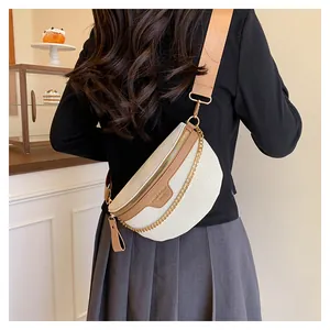 Détail du sac demi-lune blanc crème avec garniture en cuir marron et chaîne dorée