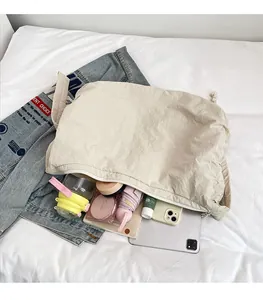 Large capacity beige nylon dumpling bag showing spacious interior with tablet and daily items