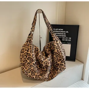Detail of leopard print tote bag with wide shoulder strap and silver metal buckle
