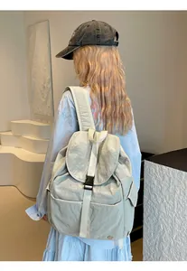 Zaino in nylon impermeabile indossato da modella con design minimalista grigio chiaro