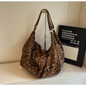 Detail view of large leopard print tote bag with adjustable strap and metal buckle