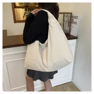 Vista dettagliata della borsa tote in nylon leggero color crema con dettagli a coulisse