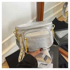 Dettaglio della borsa a tracolla argento con hardware dorato e cinturino con borchie