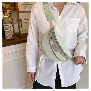 Détail du sac ceinture vert clair à motif crocodile avec chaîne dorée et sangle