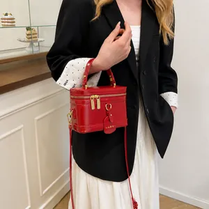 Detail der roten Vintage-Kosmetiktasche mit Goldreißverschlüssen und Schultergurt am Modell