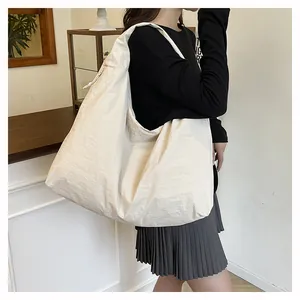 Dettaglio della borsa tote in nylon crema con texture stropicciata e coulisse laterale