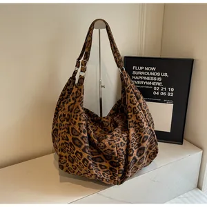 Detail of adjustable strap and silver metal buckle on leopard print tote bag