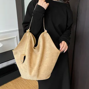 Détail du sac cabas en daim kaki avec bordure ondulée et petit accessoire assorti