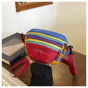 Detail view of colorful nylon waist bag showing multiple zipper compartments and adjustable strap