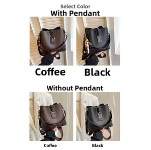 Vista detallada de bolsos cubo café y negros con colgante D y correa ancha de hombro