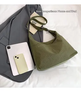 Détail du sac hobo vert matelassé avec comparaison de taille tablette et mobile