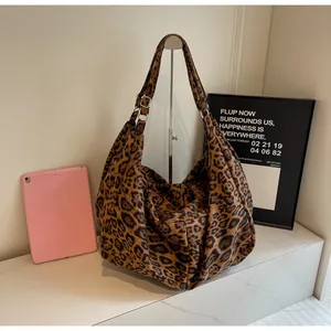 Detail of adjustable metal buckle and leopard print pattern on large tote bag