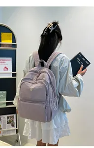 Vista posteriore della modella con zaino in nylon lilla dal design a tasche multiple
