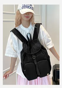 Foto di uno zaino nero in nylon impermeabile con tasche multiple indossato