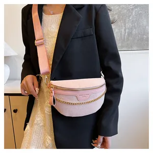 Détail du sac bandoulière rose clair semi-circulaire avec texture croco et chaîne dorée