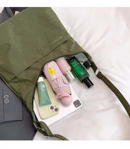 Gros plan du sac fourre-tout à carreaux vert foncé avec bandoulière et intérieur spacieux