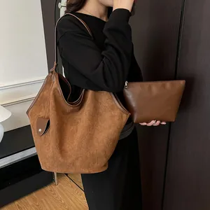 Vue détaillée d'un ensemble de cabas en daim marron avec petite pochette zippée assortie