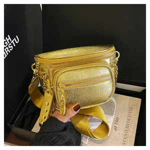 Dettaglio borsa a tracolla oro metallizzato con texture litchi e cerniere robuste