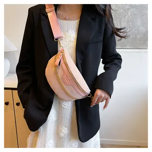 Détail du sac bandoulière rose en forme de demi-lune avec motif croco et chaîne dorée