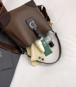 Detalle del interior espacioso del bolso bucket de cuero marrón oscuro con hebilla en D