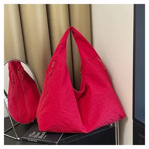 Dettaglio della borsa tote in nylon rosa con coulisse laterale e ampia tracolla morbida