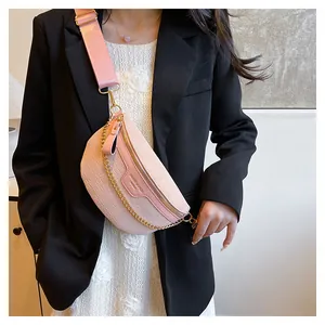 Vue détaillée du sac ceinture rose à texture croco avec chaîne dorée et large bandoulière