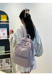 Dettaglio di uno zaino in nylon viola chiaro con tasche funzionali a cerniera multipla