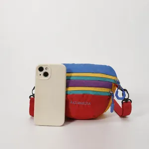 Nylon rainbow waist bag detail with phone for size reference and adjustable strap