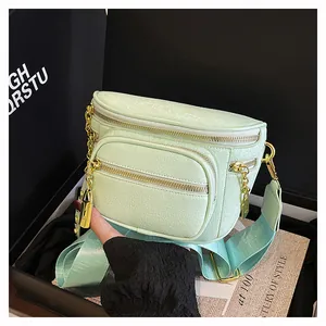 Dettaglio borsa a tracolla verde menta con trama litchi e cerniere in metallo dorato