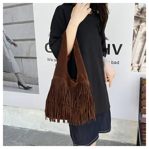 Vista dettagliata di una borsa hobo marrone scuro con lunghe nappe bohémien su una modella