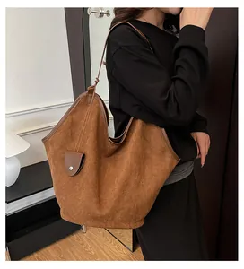 Détail du sac cabas en daim marron foncé avec texture mate et fine bandoulière
