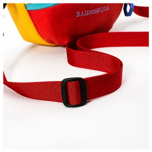 Detail view of red nylon strap with black plastic buckle and branded embroidery text