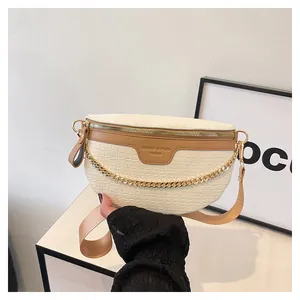 Détail de la texture crocodile et du zip doré sur un sac bandoulière demi-lune