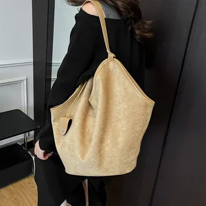 Détail du grand sac cabas avec texture en daim mat et bandoulière pour un look décontracté