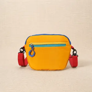Close-up of color-block nylon fanny pack with yellow body, blue trim and red strap